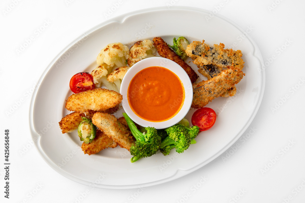 Fish fillets, chicken in batter with vegetables. Banquet festive dishes. Gourmet restaurant menu. White background. Fish fillets, chicken in batter with vegetables. Banquet festive dishes. Gourmet restaurant menu. White background.