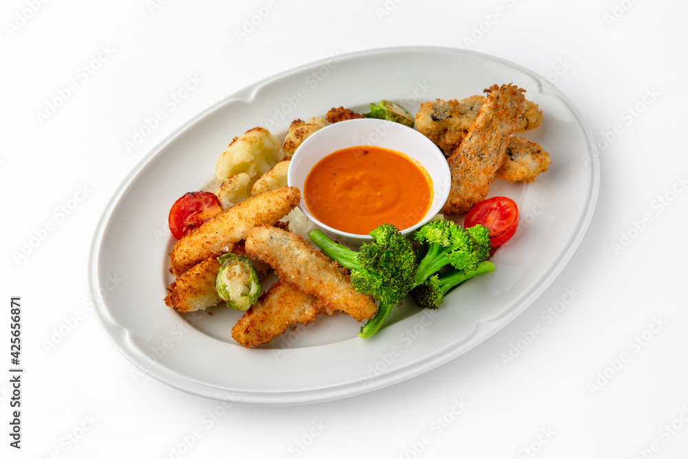 Fish fillets, chicken in batter with vegetables. Banquet festive dishes. Gourmet restaurant menu. White background. Fish fillets, chicken in batter with vegetables. Banquet festive dishes. Gourmet restaurant menu. White background.