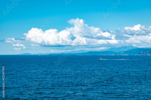 blue skies and clouds with boat passing on ocean © Mac