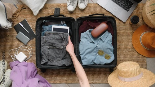 Man packing suitcase for travel vacation in new normal, top view. photo