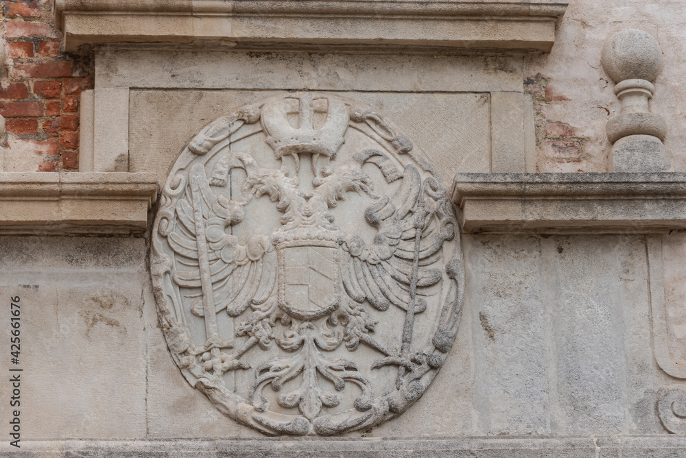 Old coat of arms on a house in the city of Brno. Bas-relief in the form of a two-headed eagle in the Czech city