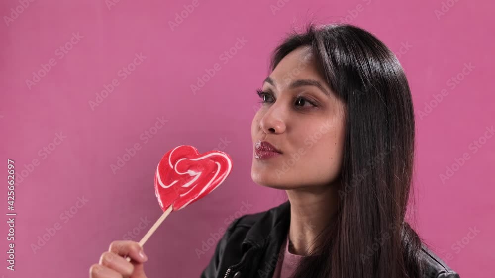 Prtetty woman licks on a giant lollipop - studio shooting Prtetty woman licks on a giant lollipop - studio shooting
