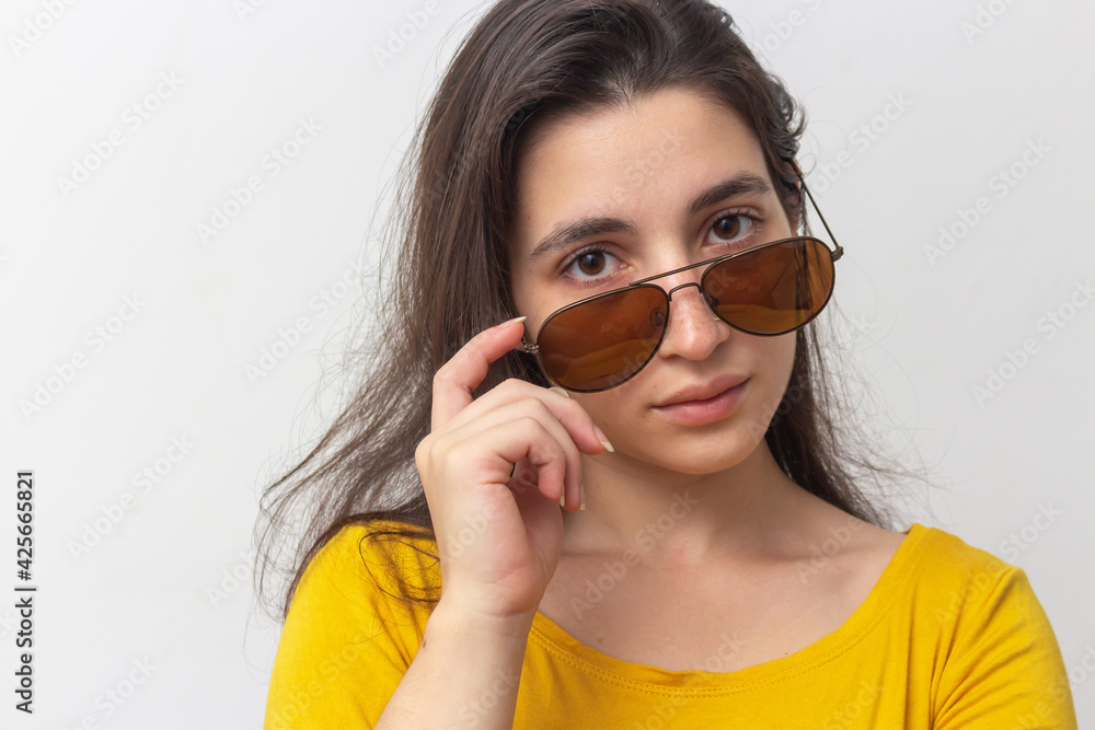Woman with yellow t-shirt on white background with brown glasses
