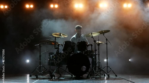 A professional drummer goes on stage and starts playing drums.