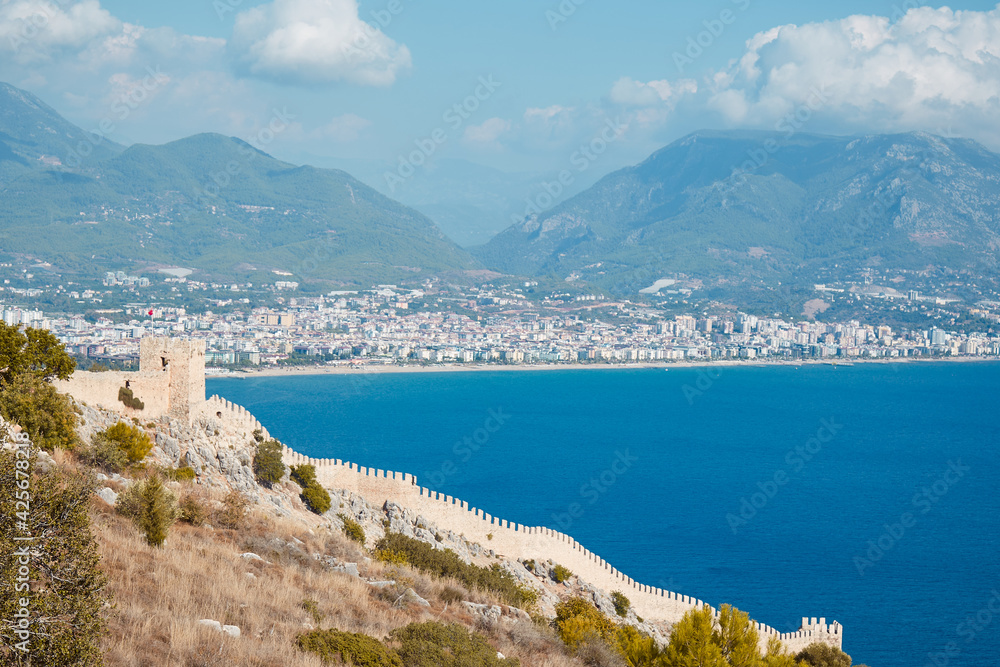 Sea panorama landscape of Alanya Castle in Antalya district, Turkey. Popular tourist destination with high mountains. Summer sunny day and beautiful sea background