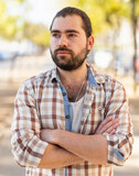 Portrait of an attractive man standing on street in a plaid shirt. High quality photo