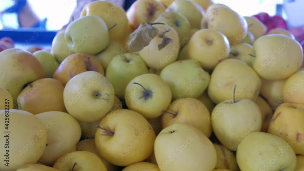 Organic pink and yellow ripe apples piled on a country market table. Weekend farmers fair. Farmer produced fruits Organic pink and yellow ripe apples piled on a country market table. Weekend farmers fair. Farmer produced fruits