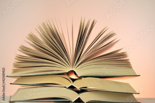 Reading books and literature.Open books stack set on a light pink background. Study and education. Close-up book pages.Learning and knowledge. 