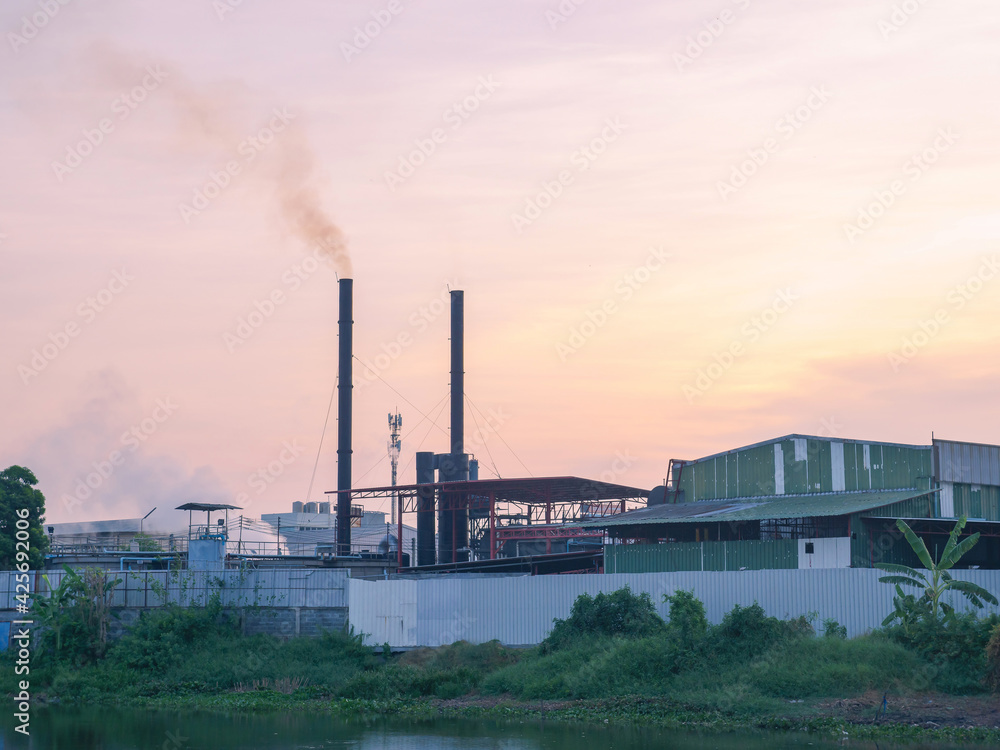 outside building of industry factory with smoke and steam from smokestack near river against twilight sky the pollution of food manufacturing contaminate to environment outside building of industry factory with smoke and steam from smokestack near river against twilight sky the pollution of food manufacturing contaminate to environment