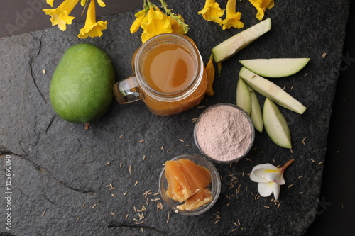 Raw Mango juice - Aam Panna or Panha in a transparent glass with whole green fruit, photo