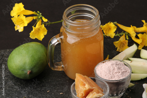 Raw Mango juice - Aam Panna or Panha in a transparent glass with whole green fruit, photo