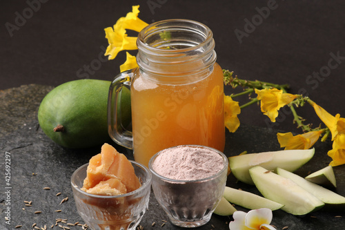 Raw Mango juice - Aam Panna or Panha in a transparent glass with whole green fruit, photo