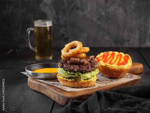 Burger with onion rings and a flag on a dark background.