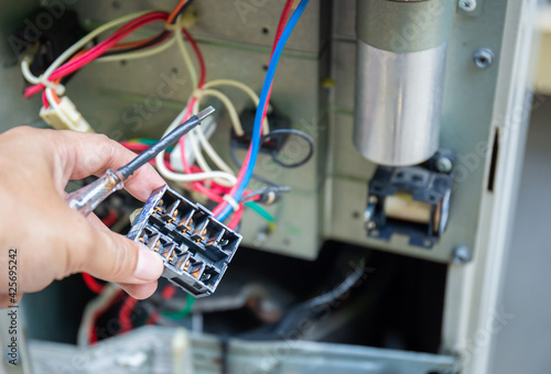 Close up of Air Conditioning Repair, repairman testing, checking, repairing of magnetic contactor and fixing air conditioning system