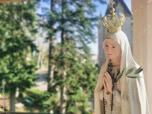 Virgin Mary statue praying with her hands joined ,with a crown. Our Lady of Fatima. Paray-le-Monial, France.