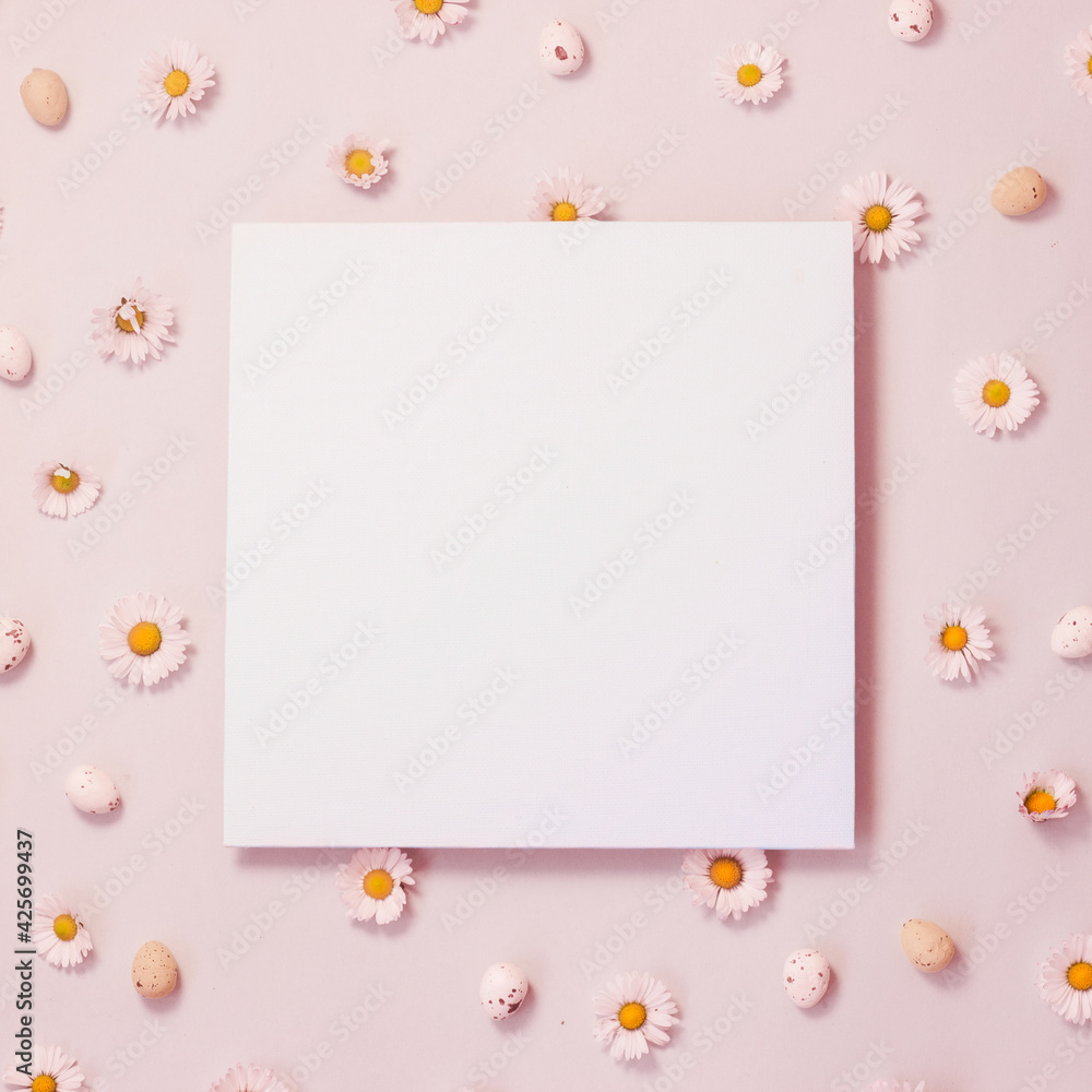 Creative layout made of daisy flowers and small decorated quail eggs. Floral background with paper card note. Spring or Easter background