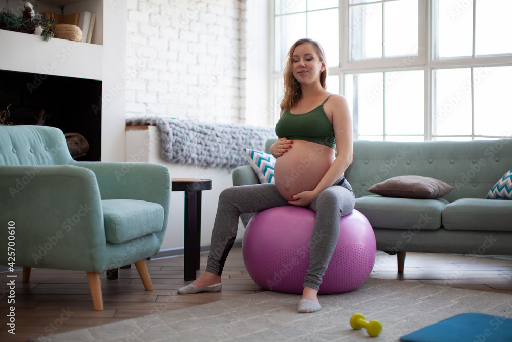 Obraz premium Young pregnant women doing exercise using a fitness ball