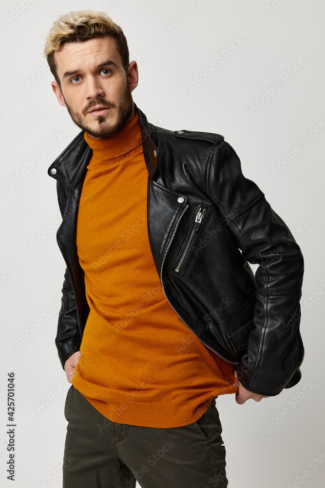 stylish blond man in a sweater and a leather jacket on a light background stylish blond man in a sweater and a leather jacket on a light background