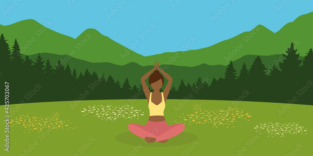 sporty girl makes yoga on a summer meadow with mountain landscape