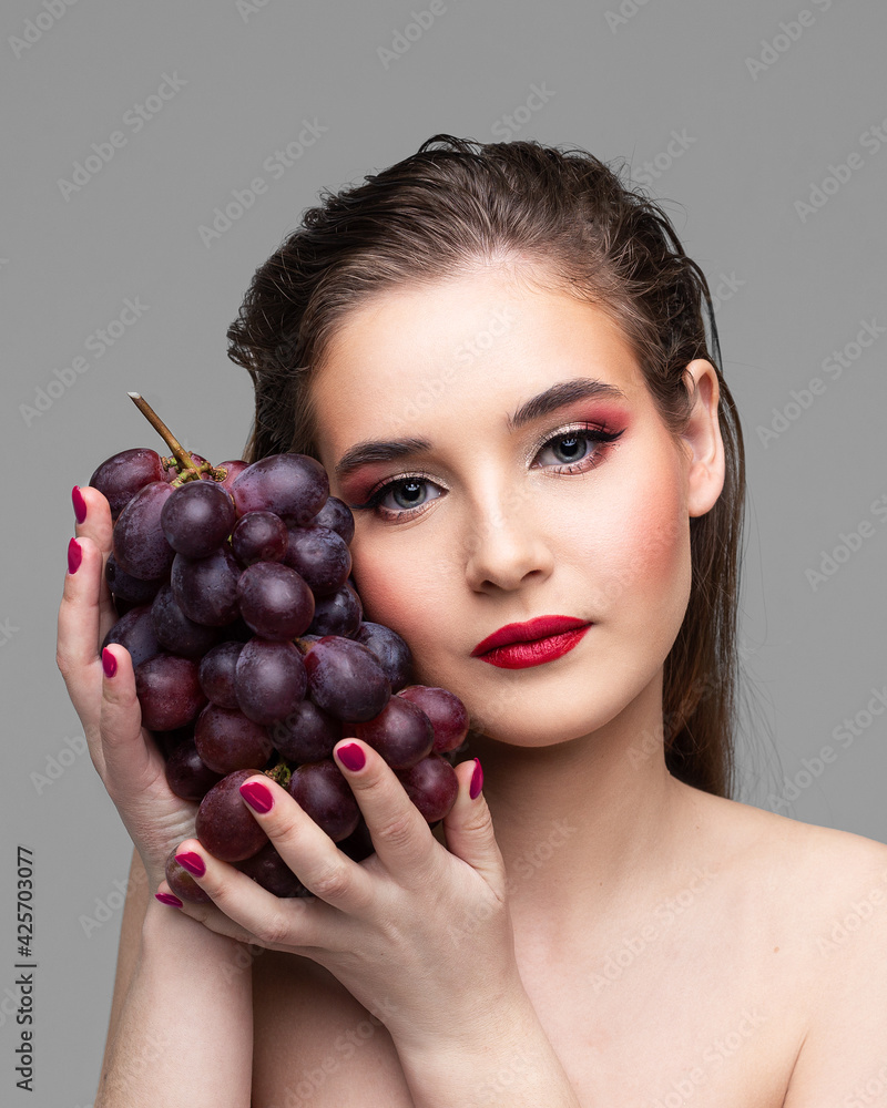 Girl with a branch of purple grapes, bright lips, loose hair
Girl with a branch of purple grapes, bright lips, loose hair