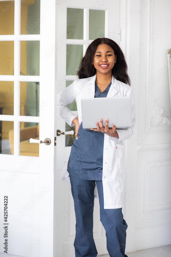 black skinned female medic smiling standing on a white background with papers in hand black skinned female medic smiling standing on a white background with papers in hand
