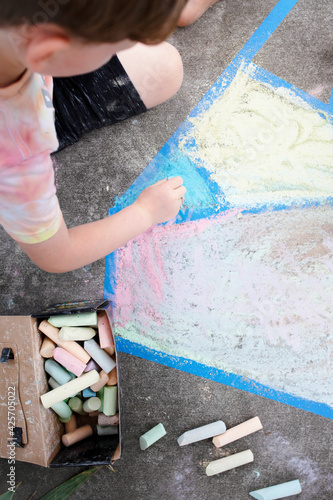 Kid painting concrete ground with a chalk education photography