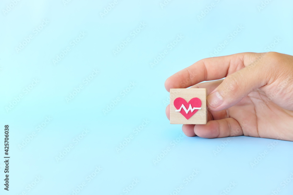 Hand choosing healthcare heartbeat icon on wooden blocks with copy space. Health top priority and medical insurance concept. Hand choosing healthcare heartbeat icon on wooden blocks with copy space. Health top priority and medical insurance concept.