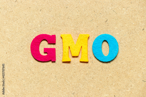 Color cloth alphabet letter in word GMO (abbreviation of Genetically Modified Organisms) on wood background