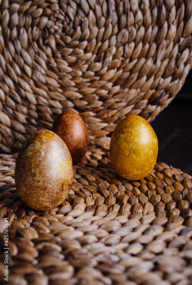 golden eggs on wicker natural background, easter eggs, unusual stylish food design golden eggs on wicker natural background, easter eggs, unusual stylish food design