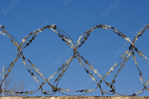 barbed wire on the fence and blue sky