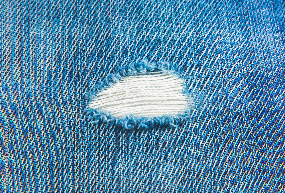 Ripped blue hipster jeans material. Destroyed denim Cloth texture. Close  up. Stock Photo | Adobe Stock