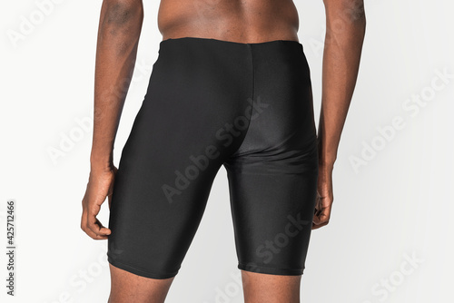 Man in black compression shorts for swimwear fashion shoot rear view photo