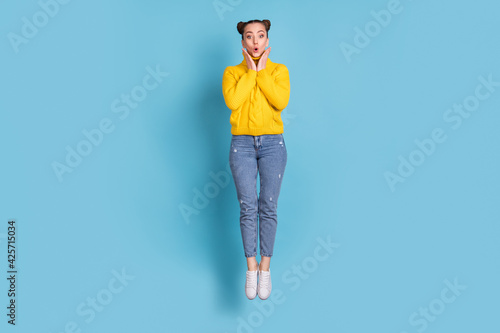 Full length body size view of attractive amazed cheerful girl jumping pout lips isolated over vibrant blue color background © deagreez