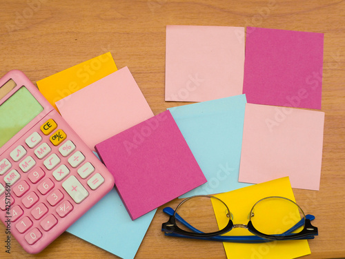 Several notepads and a pink number calculator with glasses.