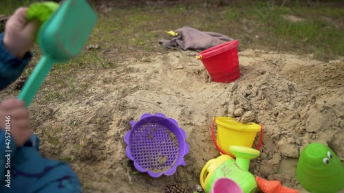 Kids sandbox toys in use. Modern cinematic tracking dolly shot. photo