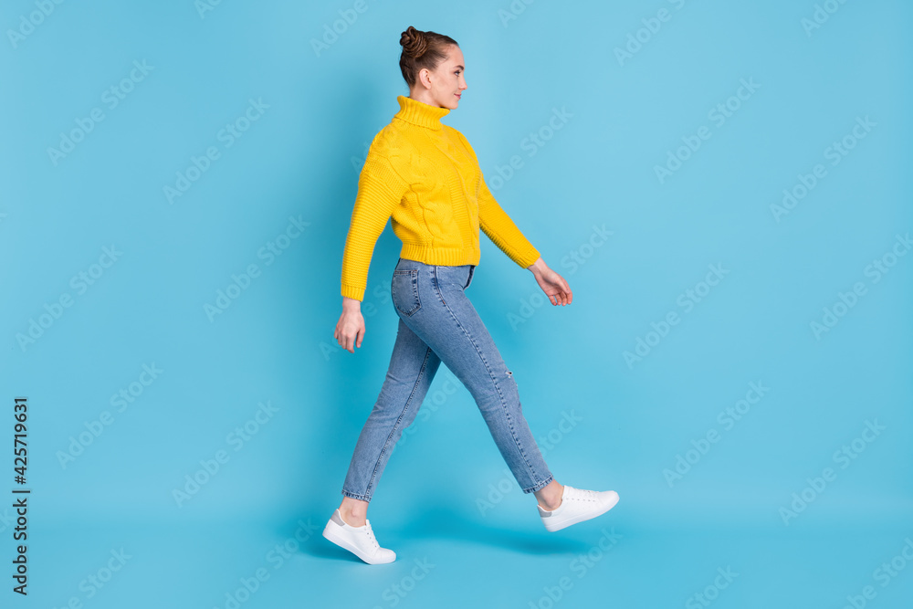 Full body profile portrait of pretty person walking look empty space wear pullover isolated on blue color background Full body profile portrait of pretty person walking look empty space wear pullover isolated on blue color background