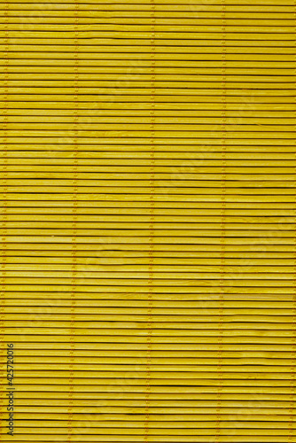 Wooden blinds on the mustard-colored windows.Texture or background