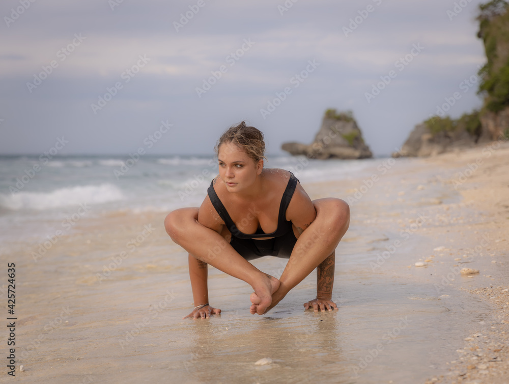 Ourdoor yoga. Attractive woman practicing Bhujapidasana, Arm Pressure Balance on the beach. Strong healthy body. Healthy lifestyle. Yoga retreat. Copy space. Thomas beach, Bali Ourdoor yoga. Attractive woman practicing Bhujapidasana, Arm Pressure Balance on the beach. Strong healthy body. Healthy lifestyle. Yoga retreat. Copy space. Thomas beach, Bali