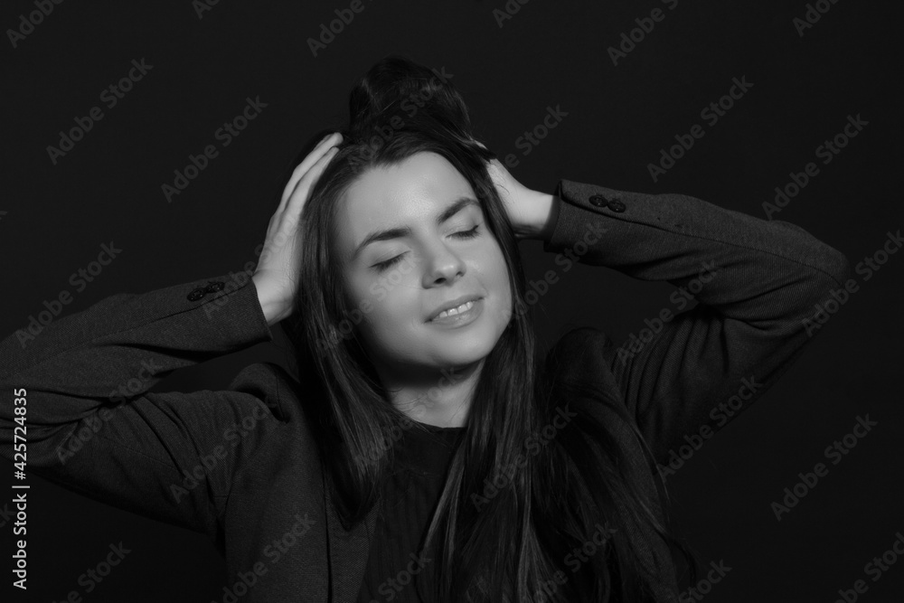 Black and white portrait of a young brunette woman in a studio on a black background Black and white portrait of a young brunette woman in a studio on a black background