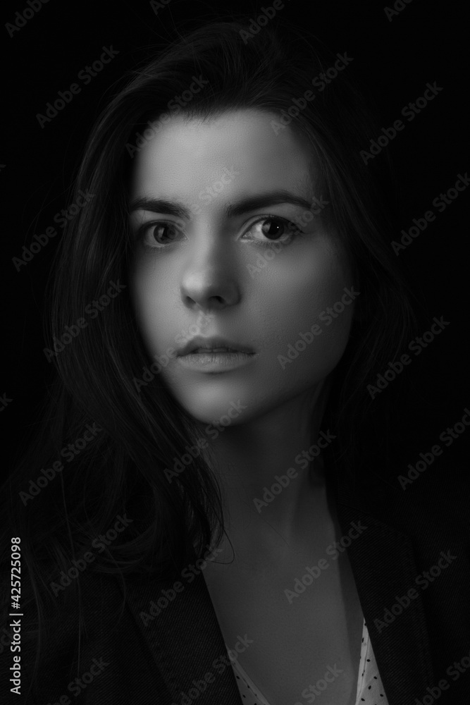 Black and white portrait of young brunette woman in a studio on a black background Black and white portrait of young brunette woman in a studio on a black background