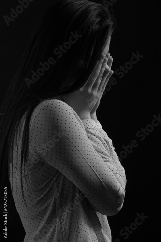 Black and white portrait of a young brunette woman in a studio on a black background