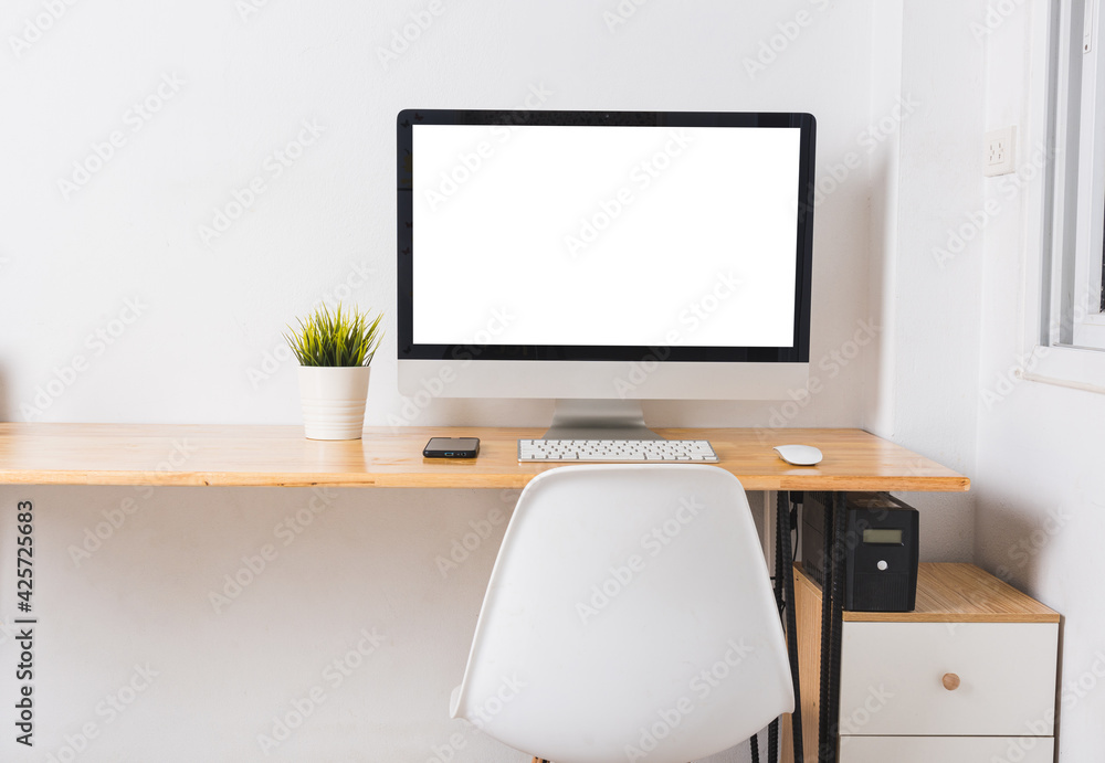 Computer monitor with white blank screen on the business desk with wireless mouse, keyboard at home office over white wall background, Photo of equipment contemporary workspace