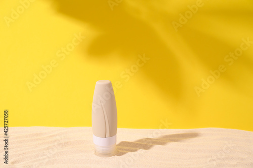 Summer tropical background with sand and shadow of leaves . Yellow and beige colors. Front view. Copy space