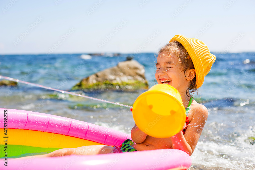Girl in yellow straw hat plays with the wind, water and a water ...