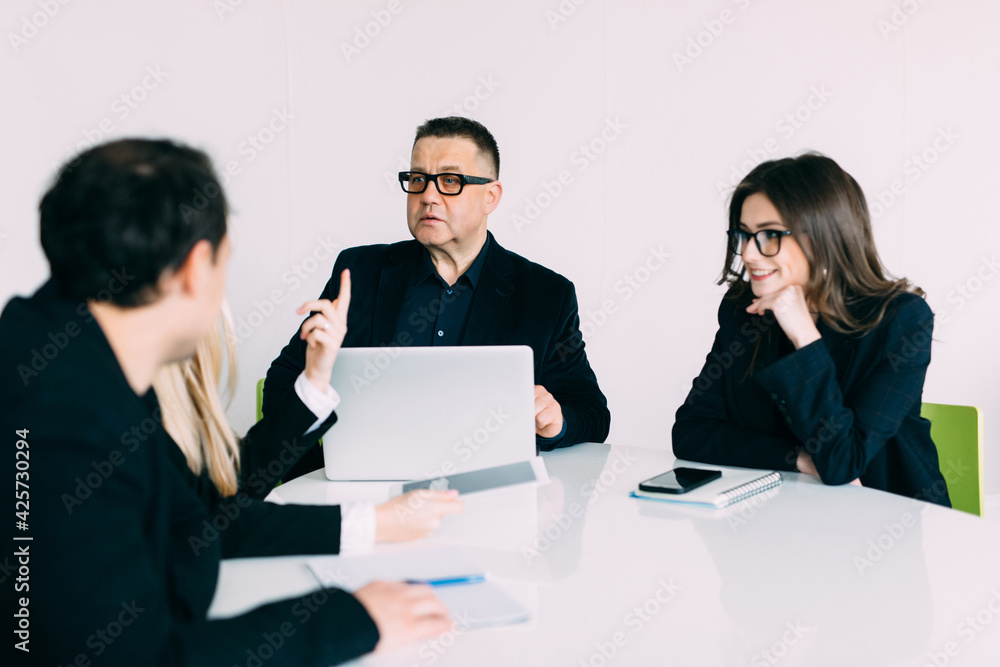 Businesspeople discussing together in conference room during meeting at office. Team work. Businesspeople discussing together in conference room during meeting at office. Team work.