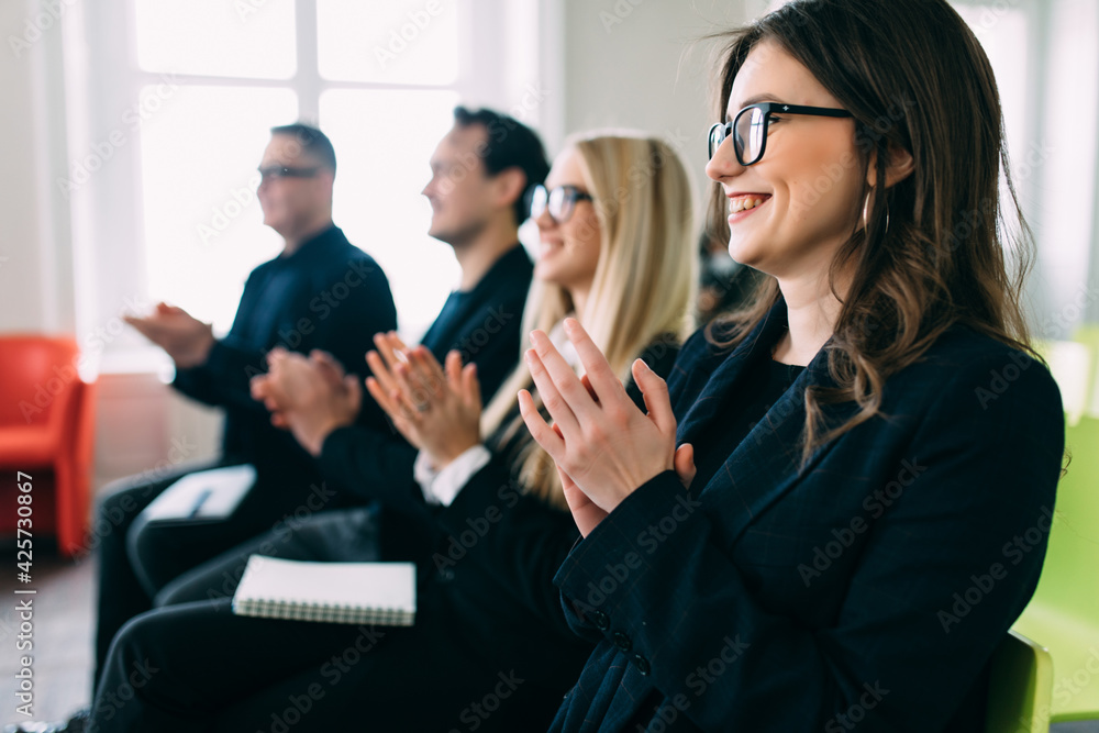 Happy smiling business team clapping hands during a meeting in business office Happy smiling business team clapping hands during a meeting in business office
