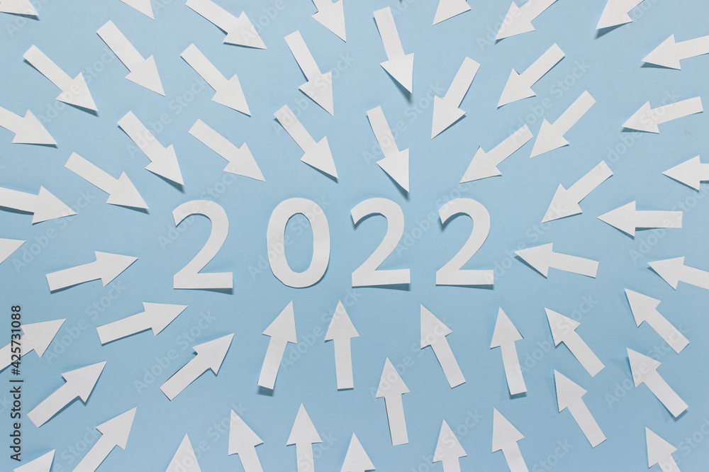 Year 2022 numbers made of white paper with pointing arrows on blue background. Year 2022 numbers made of white paper with pointing arrows on blue background.