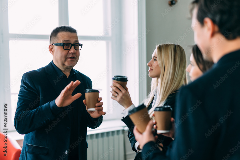 Young business people chatting and drinking coffee at a conference in the office Young business people chatting and drinking coffee at a conference in the office