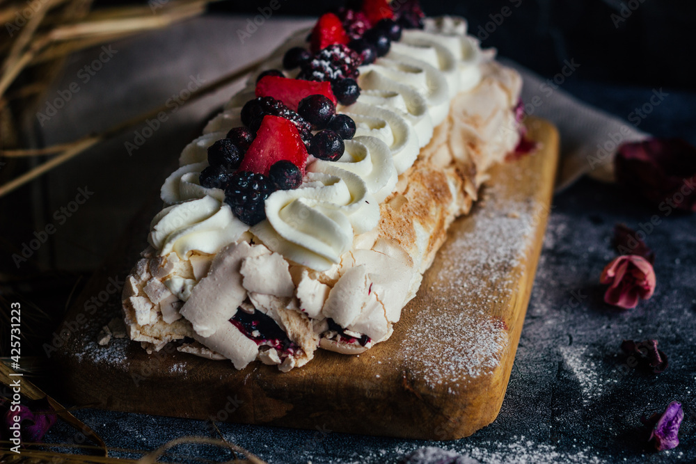 Meringue roll with berries. Delicious meringue roll on the table Meringue roll with berries. Delicious meringue roll on the table