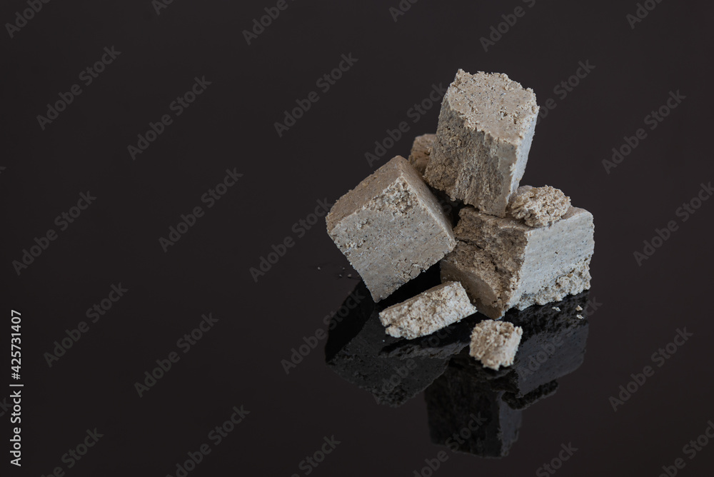 Halva pieces on a black glass background. Horizontal orientation, copy space. Halva pieces on a black glass background. Horizontal orientation, copy space.